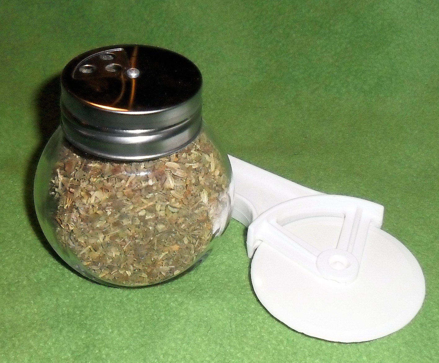 Pizza Pie shaker with not label and pizza cutter in background