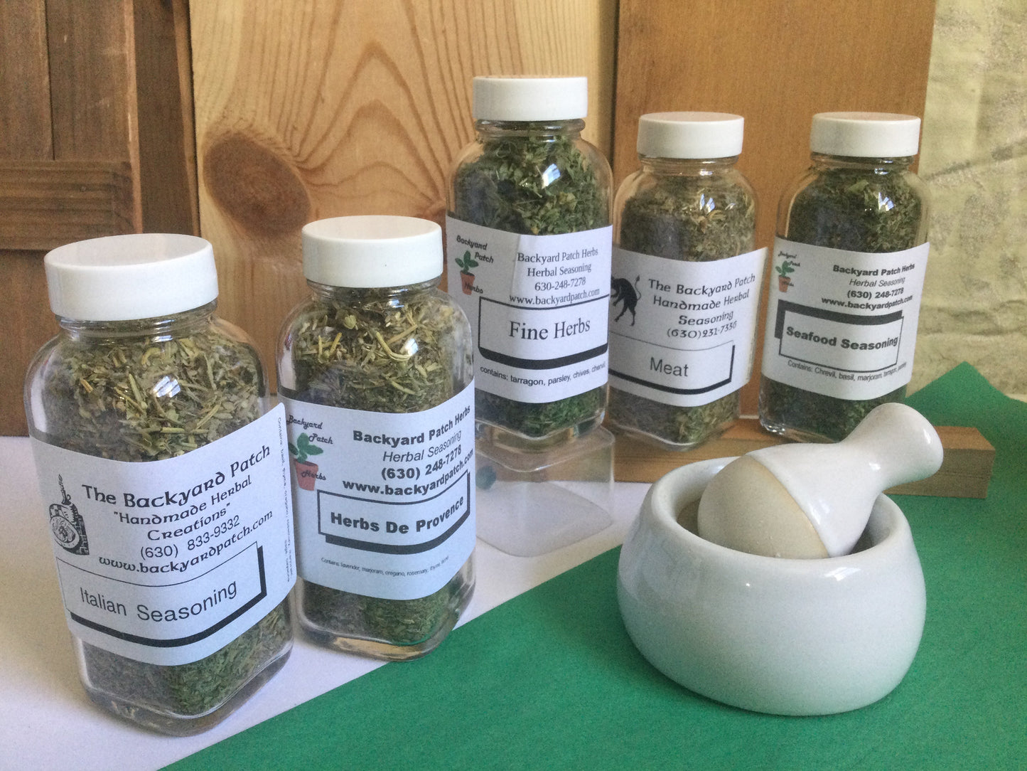 Set of five Herb Seasoning jars with a mortor and pestle in front