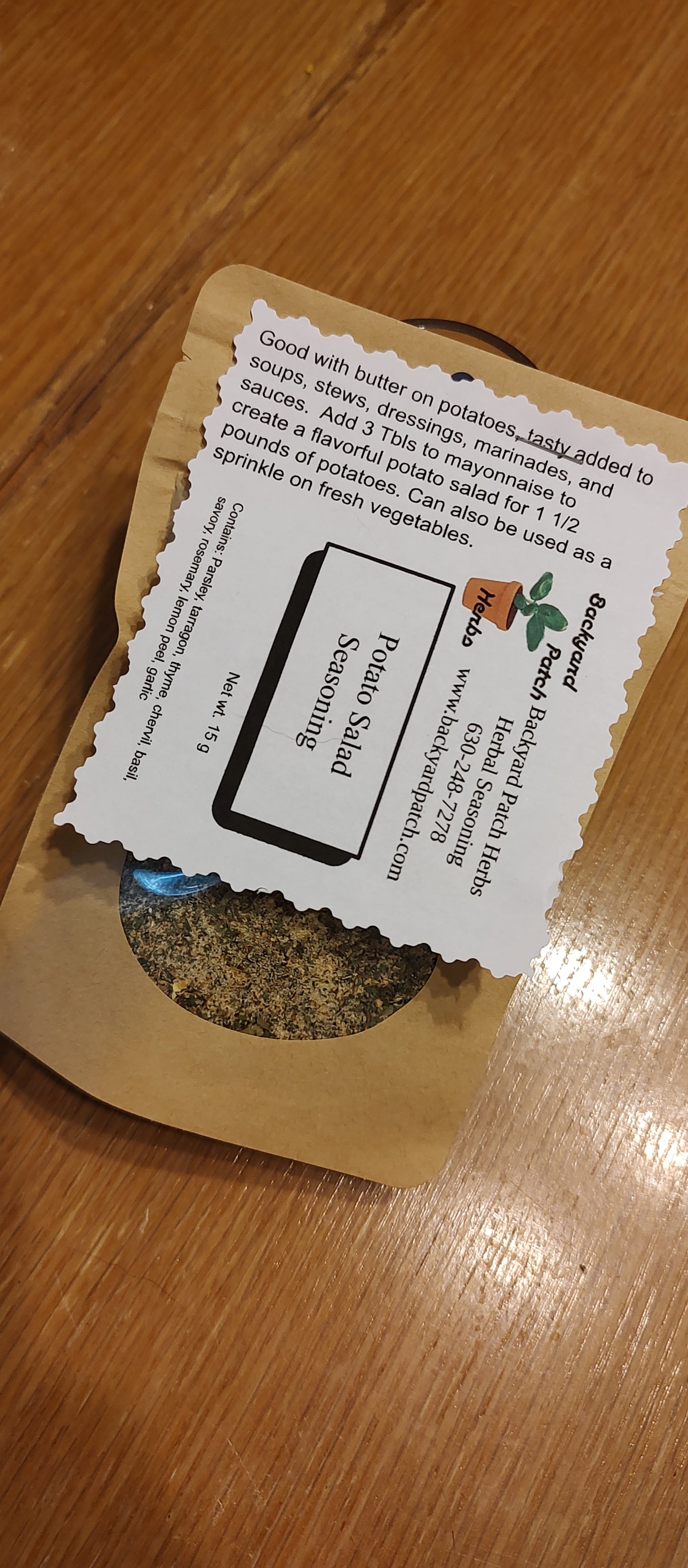 eco kraft bag of Herbal seasoning labeled 'Potato Salad Seasoning' on a wooden surface